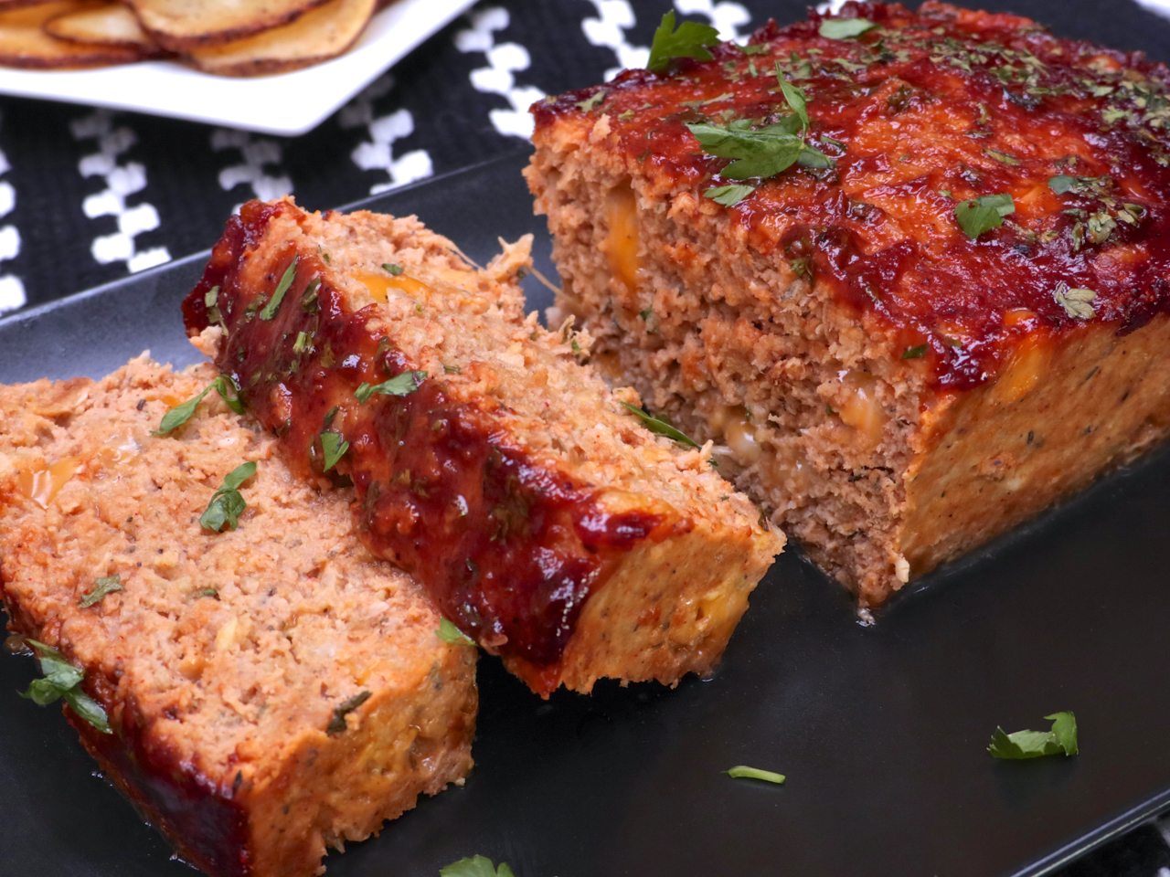 Moist, cheesy turkey meatloaf recipe seasoned with spices and topped with B...