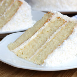 Slice of moist coconut cream cake with whipped coconut cream cheese frosting