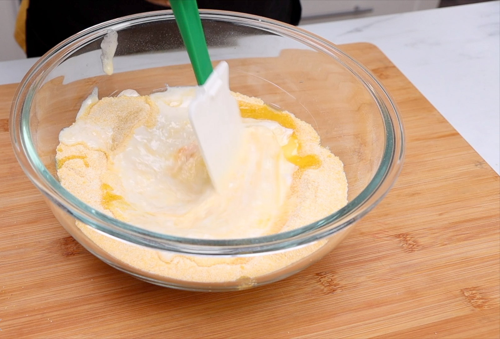 Mixing dry hush puppy ingredients with wet ingredients.