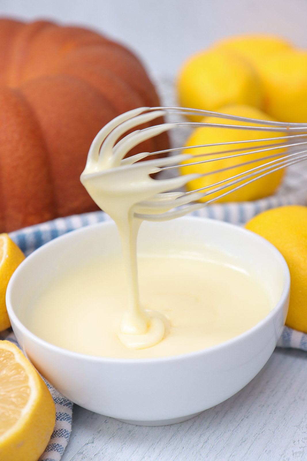 Creamy lemon glaze recipe in a bowl with whisk